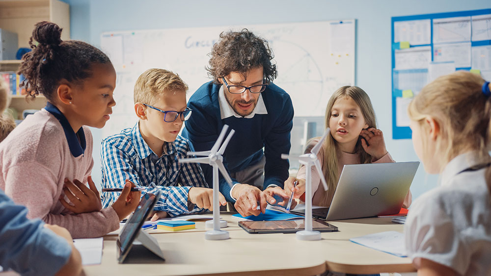 Teacher helping students with computers